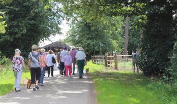 People walking on a tarmac path in the countryside